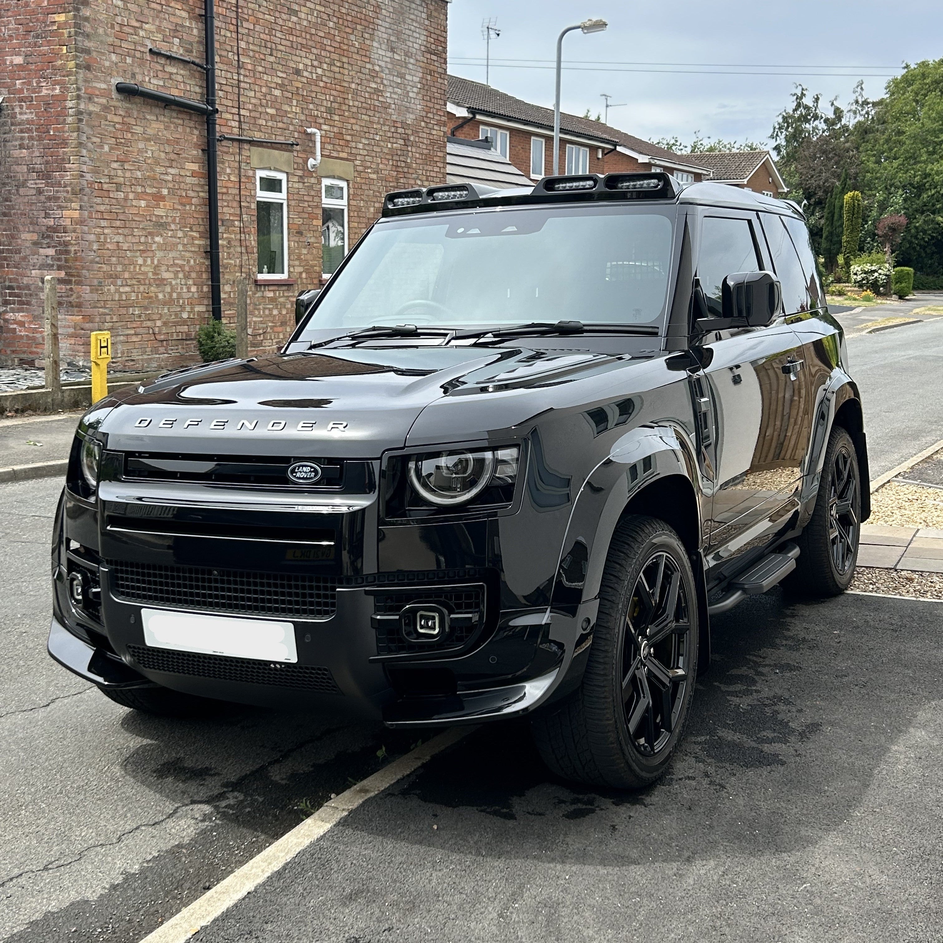 Black Land Rover Defender looking shiny after ceramic coating package