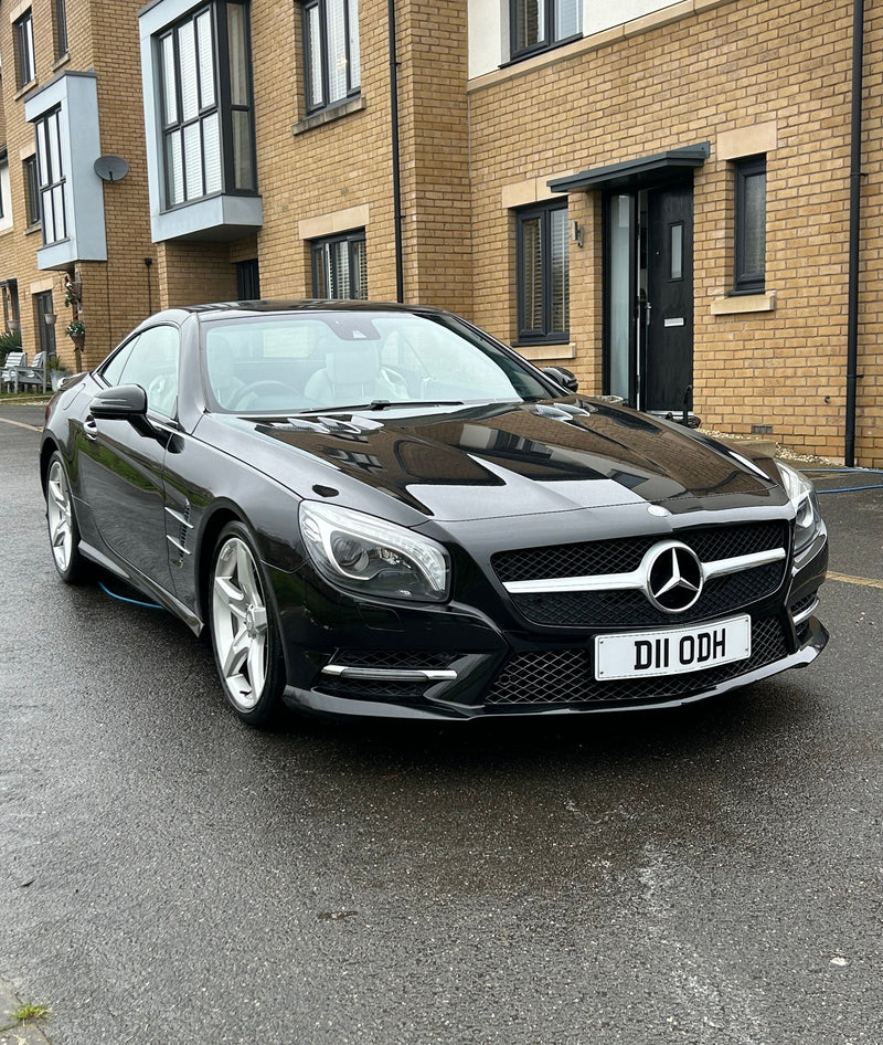 Black Mercedes-Benz car parked on a street after a car detail with the paint looking clean and glossy