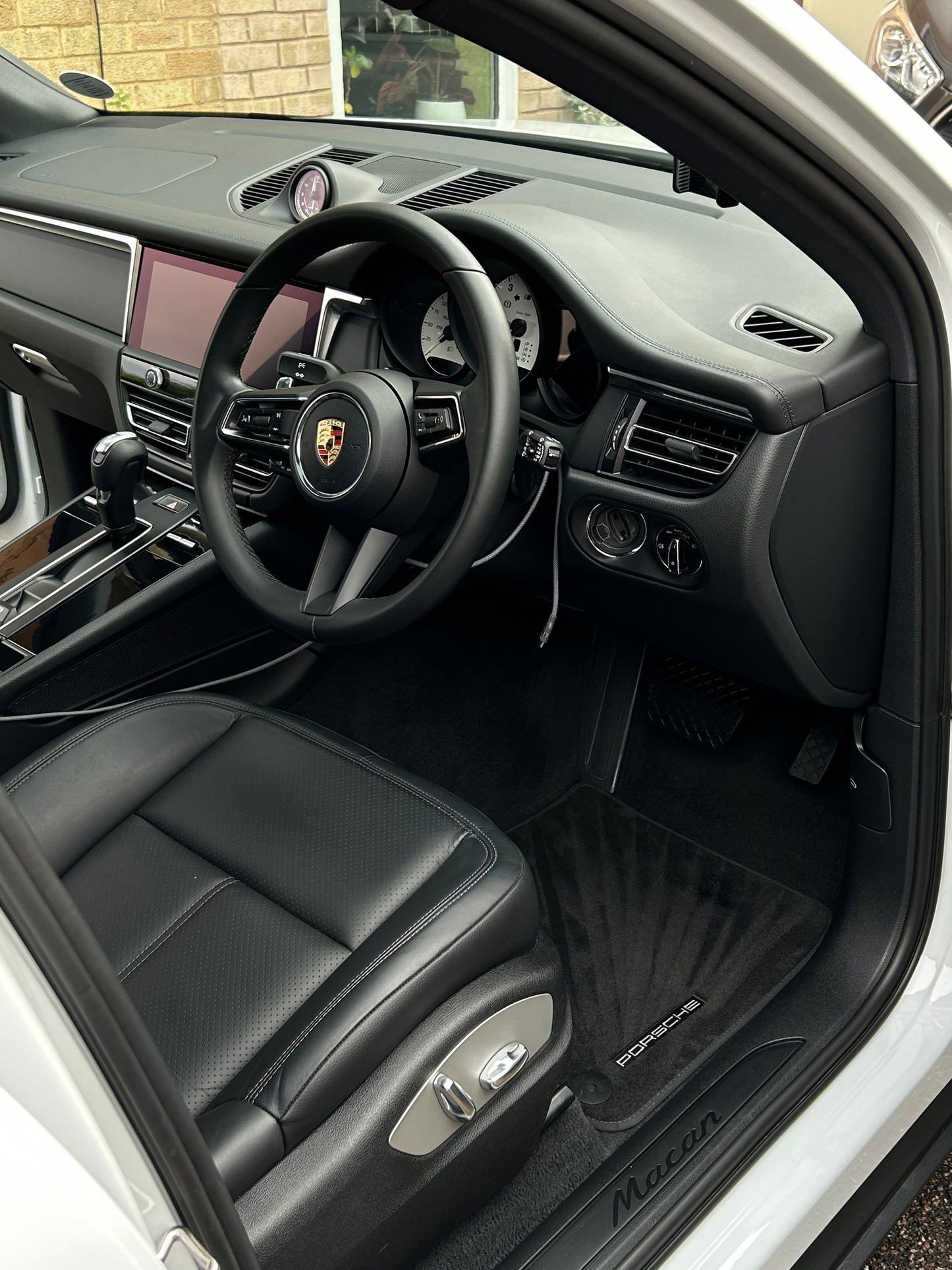 Porsche car interior with steering wheel and dashboard, featuring Porsche logo all clean.